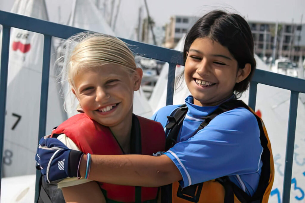 girls hugging, sailing teammates.