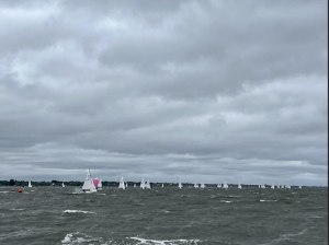 sailboats racing on a dark sea, cloudy and overcast