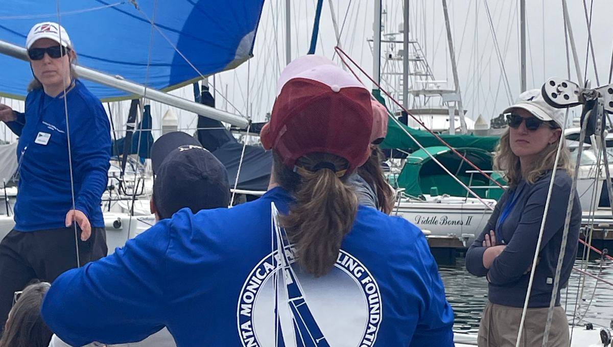 A group learning spinnaker trim at the dock