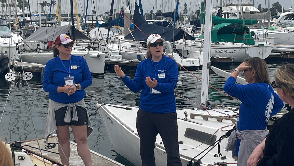 Stine Cavacas and Lindsay Artof teaching about the spinnaker at the dock