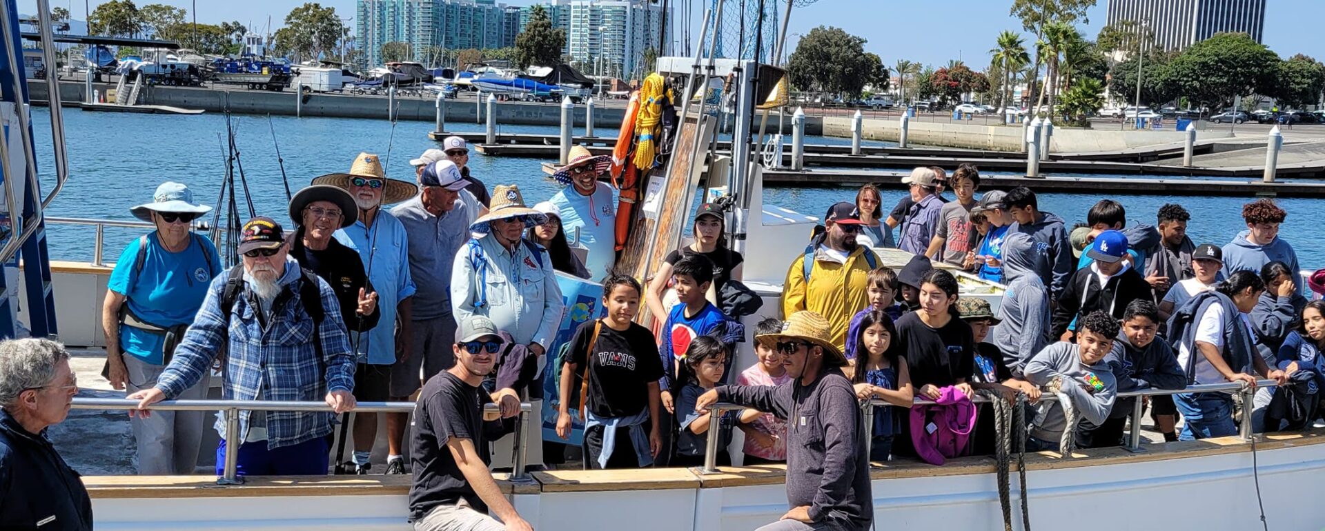 A group of kids on a boat with fishing gear